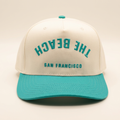 The Beach SF cream and teal Flip hat on an off-white background