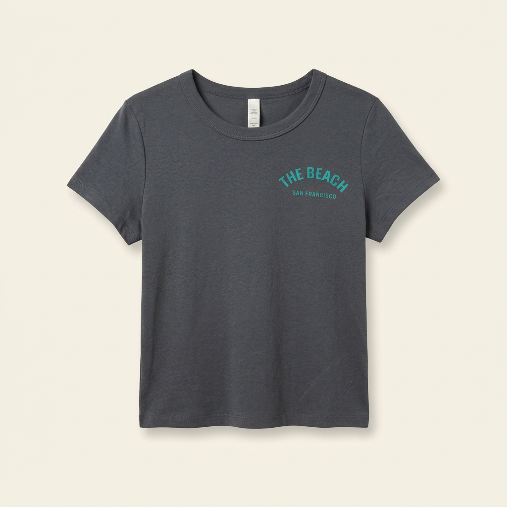 Denim-colored women's tee with teal The Beach chest logo, front