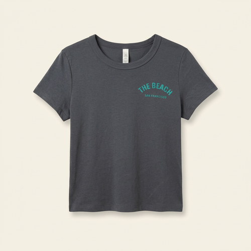 Denim-colored women's tee with teal The Beach chest logo, front